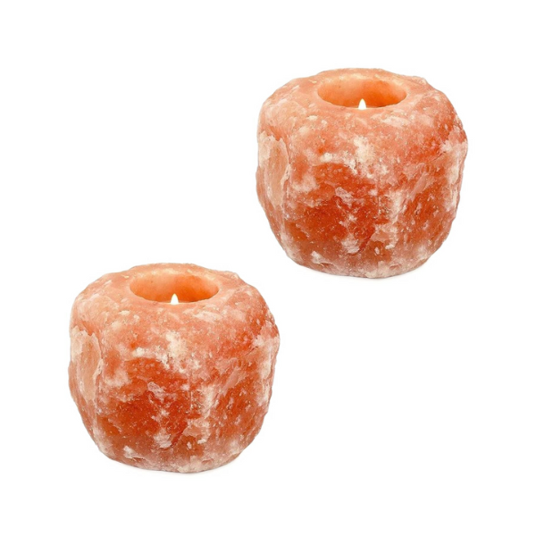 Two pink Himalayan salt candle holders, each with a lit tealight candle