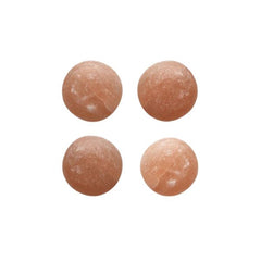 Four round polished Himalayan salt massage stones on a white background