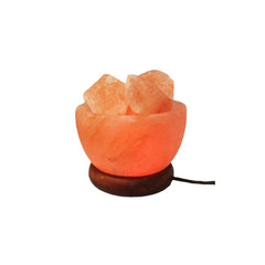 Fire bowl Himalayan salt lamp filled with glowing chunks on a dark wood base
