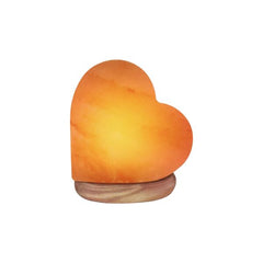 Heart-shaped Himalayan salt lamp glowing amber on a white background