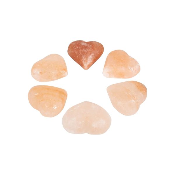 Six heart-shaped Himalayan salt massage stones arranged in a circle on a white background