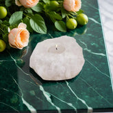 White Himalayan salt crystal candle holder with a lit tealight, styled with peach roses on a green marble table