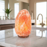 Himalayan salt lamp glowing on a marble kitchen counter near a sink