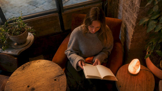 Woman adjusting glowing Himalayan salt lamp