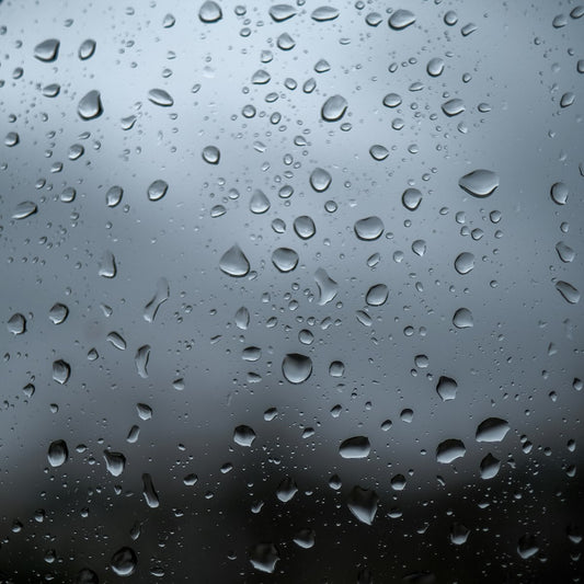 Water droplets condensing on a window, illustrating indoor humidity that affects salt lamps