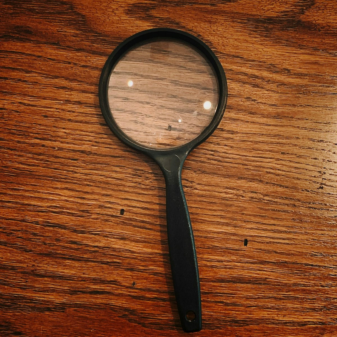 Magnifying glass inspecting an object closely, illustrating how to check if a salt lamp is genuine