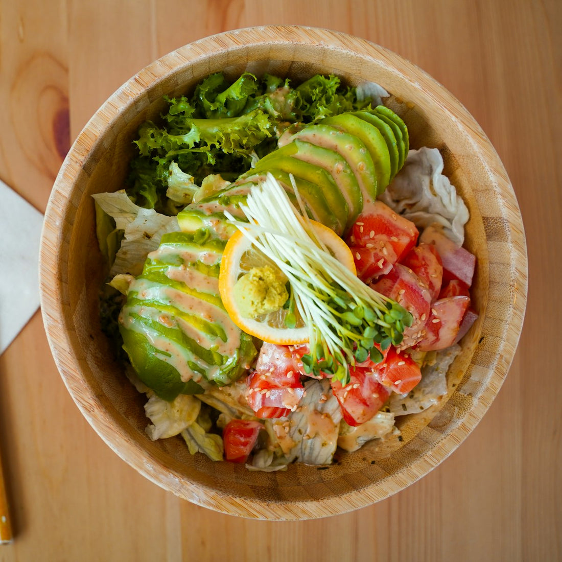 Fresh vegetable salad in a wooden bowl, a vegan dish finished with pink Himalayan salt