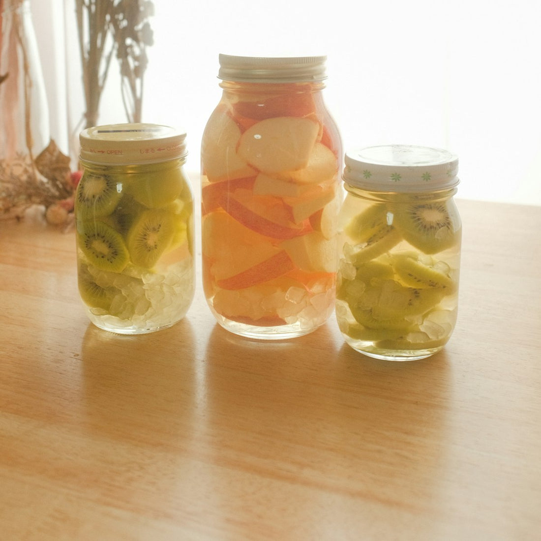 Three glass jars filled with brined pickles, showing how salt brine preserves and flavours food