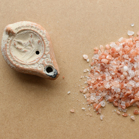 Natural sea salt crystals beside raw stone, illustrating unrefined salt purity