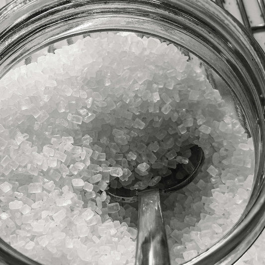 Close-up of coarse, unrefined salt crystals with no additives in a glass jar