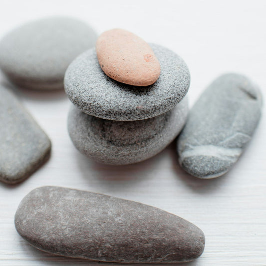 Smooth grey and pink mineral stones stacked together, symbolising mineral-rich natural salt