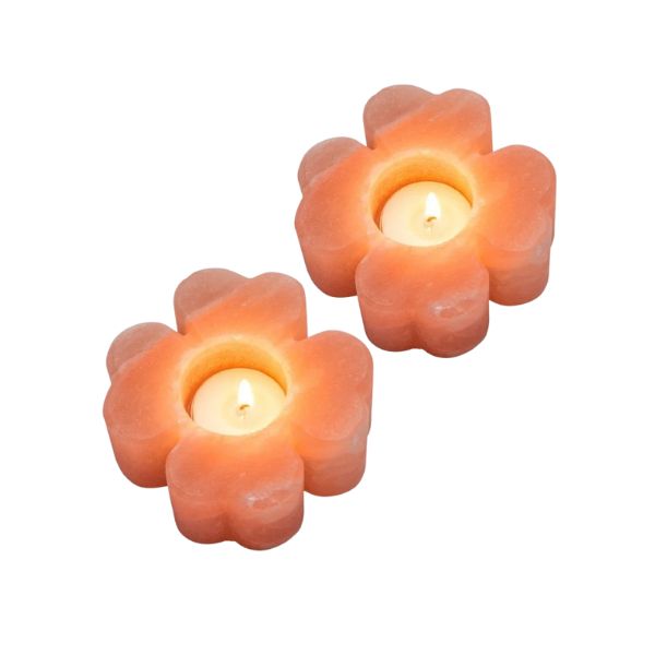 Two flower-shaped Himalayan salt candle holders, each with a lit tealight candle