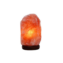 3 to 5kg natural Himalayan salt lamp on a dark wood base, glowing amber