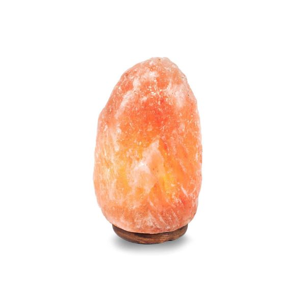 Natural Himalayan salt lamp glowing amber on a dark wood base against a white background