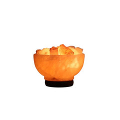 Fire bowl Himalayan salt lamp filled with glowing rock chunks on a dark wood base against a white background