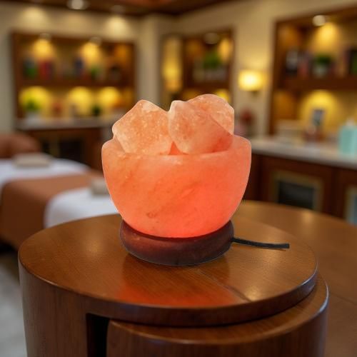 Fire bowl Himalayan salt lamp glowing on a round wooden table in a spa setting