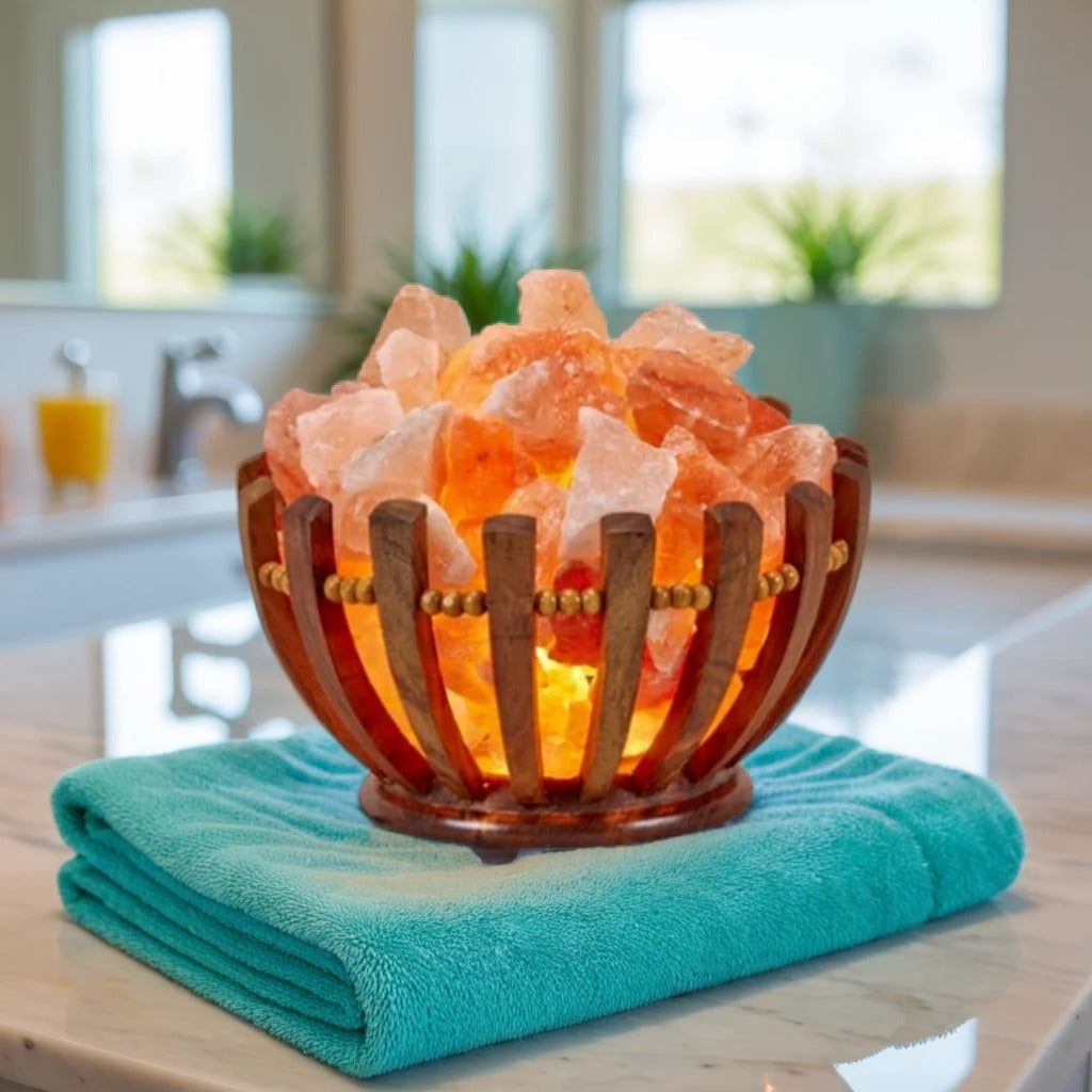 Himalayan salt chunks glowing in a wood-slat bowl lamp, set on a teal towel in a bathroom