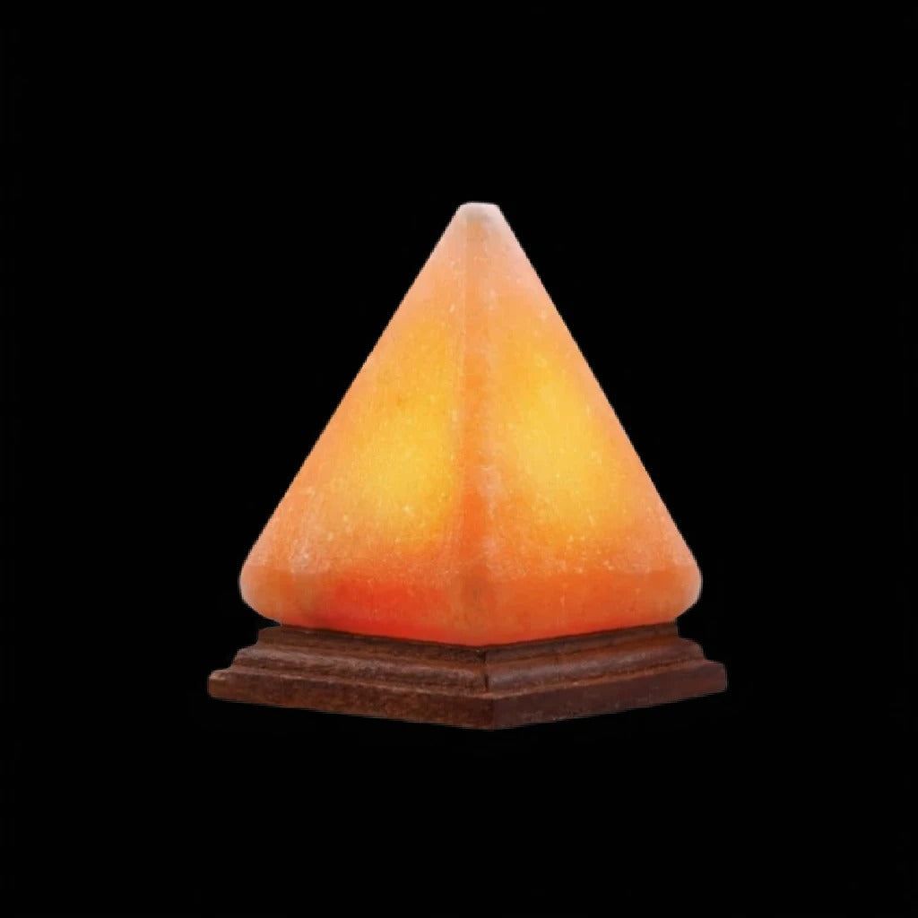 Pyramid-shaped Himalayan salt USB lamp glowing amber on a wooden base against a black background