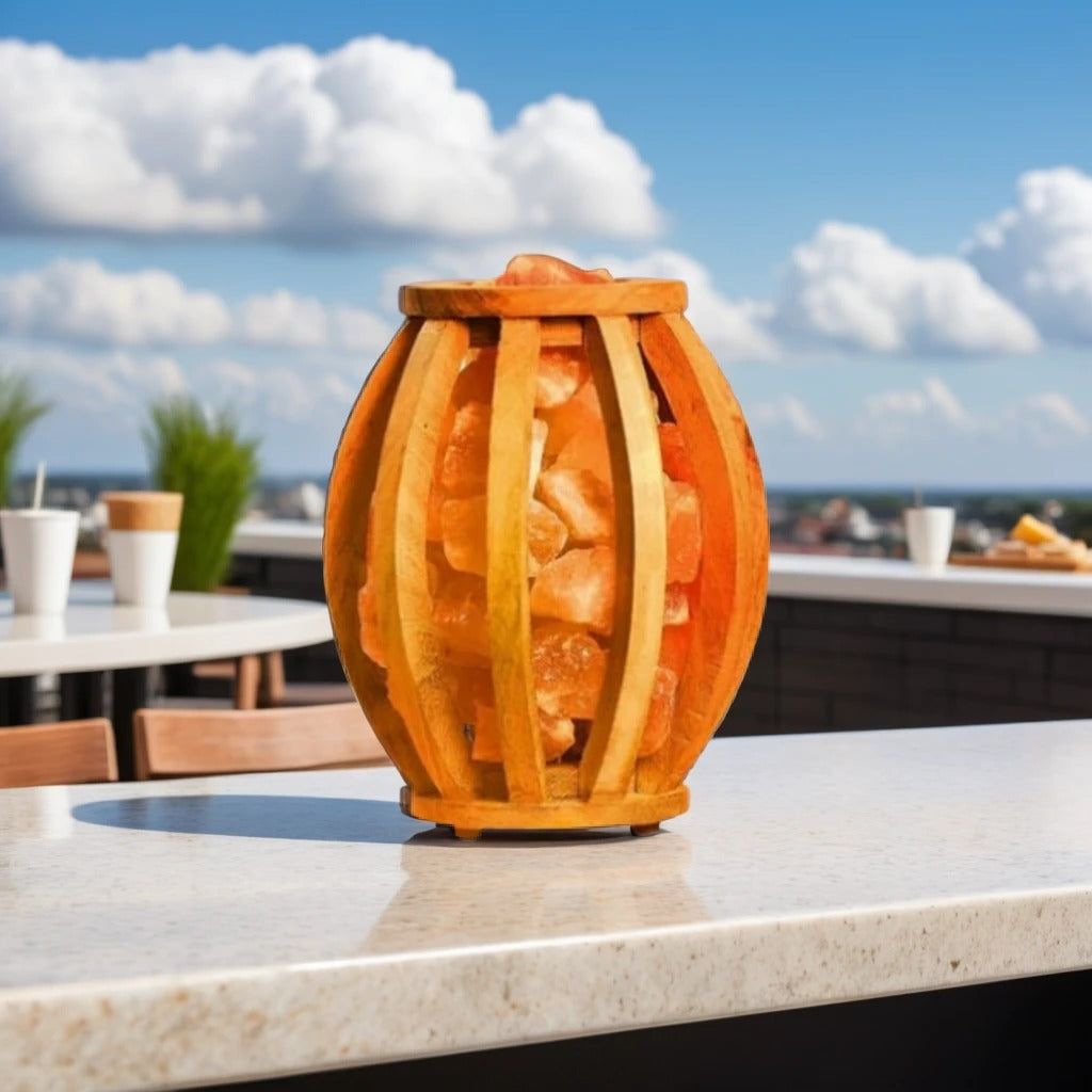 Barrel-shaped wood-slat salt lamp filled with pink Himalayan salt chunks on an outdoor rooftop counter
