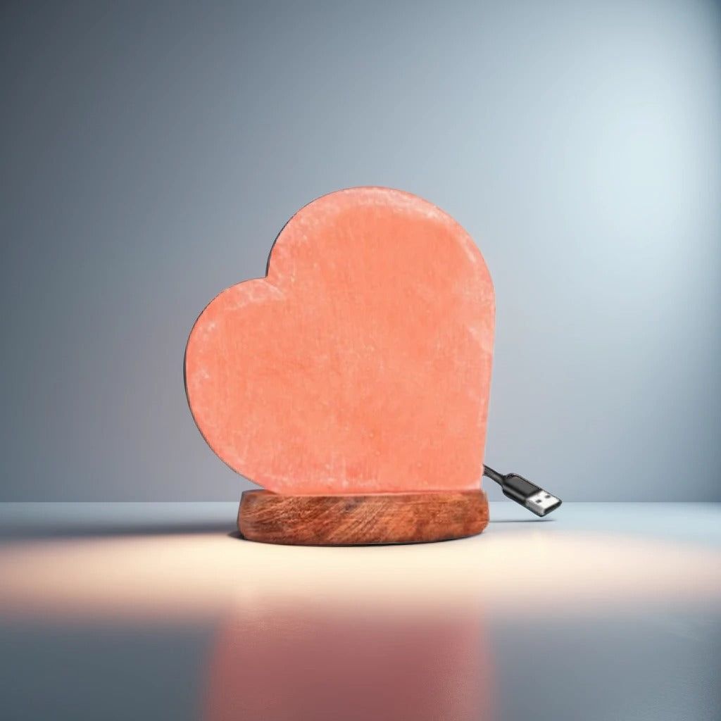 Heart-shaped Himalayan salt USB lamp on a wooden base against a dark blue backdrop