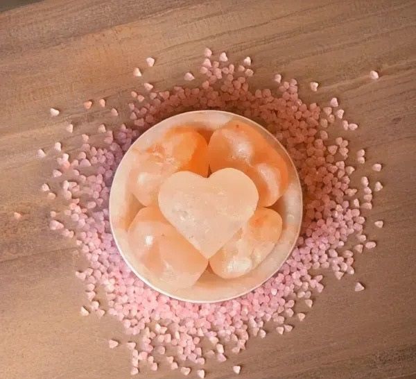 Fire bowl salt lamp with heart stone surrounded by scattered pink heart-shaped salt sprinkles