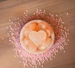 Fire bowl salt lamp with heart stone surrounded by scattered pink heart-shaped salt sprinkles