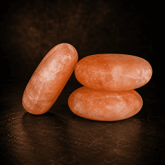 Himalayan Salt Oval Massage Stones (Set of 2) – studio photo lit against a dark background
