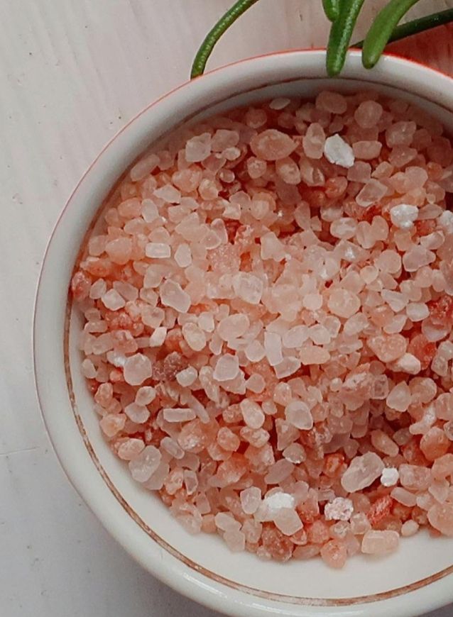 Close-up of coarse Himalayan pink salt crystals in a white bowl