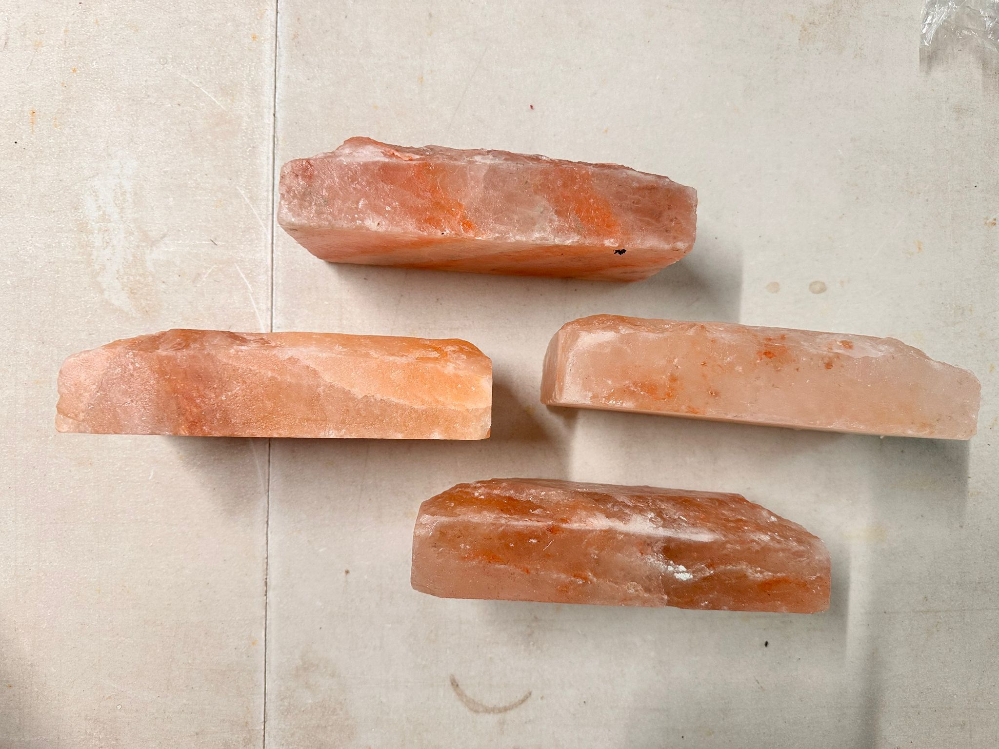 Four individual Himalayan salt tile slices laid out, showing their thin flat profile